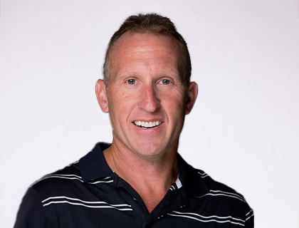 Headshot of Kevyn Syverson. A man with short brown hair and a dark blue striped polo shirt