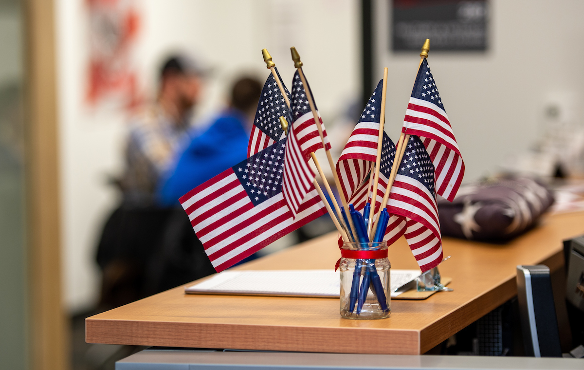 Several United States flags displayed on a desk 