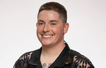 Headshot of Morgan Anderson, a person with buzzed brown hair and a patterned black shirt