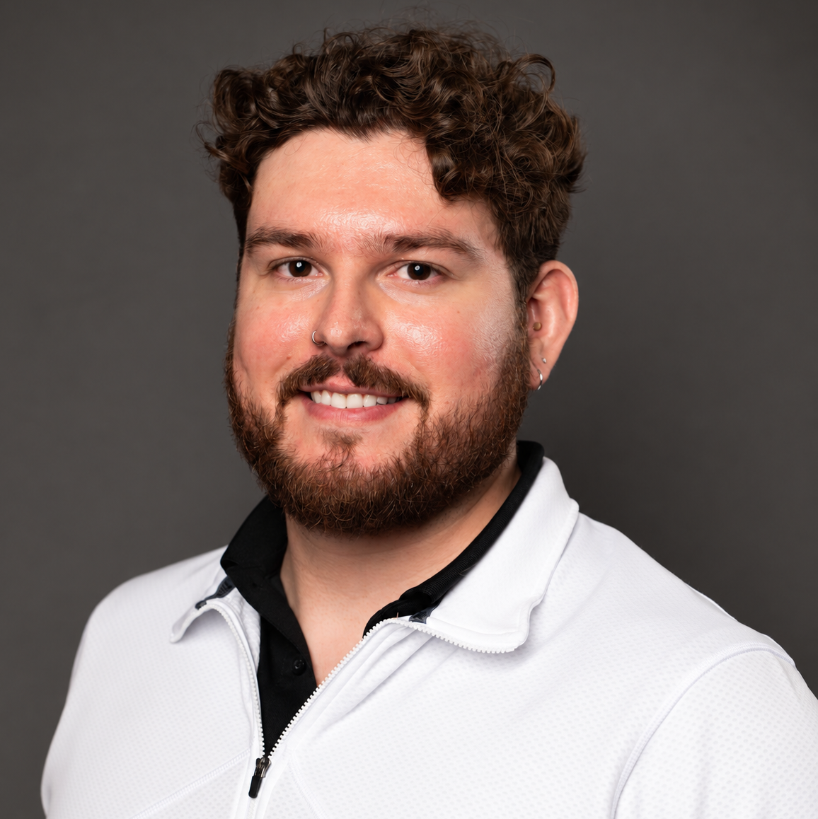 Photo of DRC Director, Ryan. Ryan is has curly brown short hair and a short beard. He is wearing a white collared shirt.