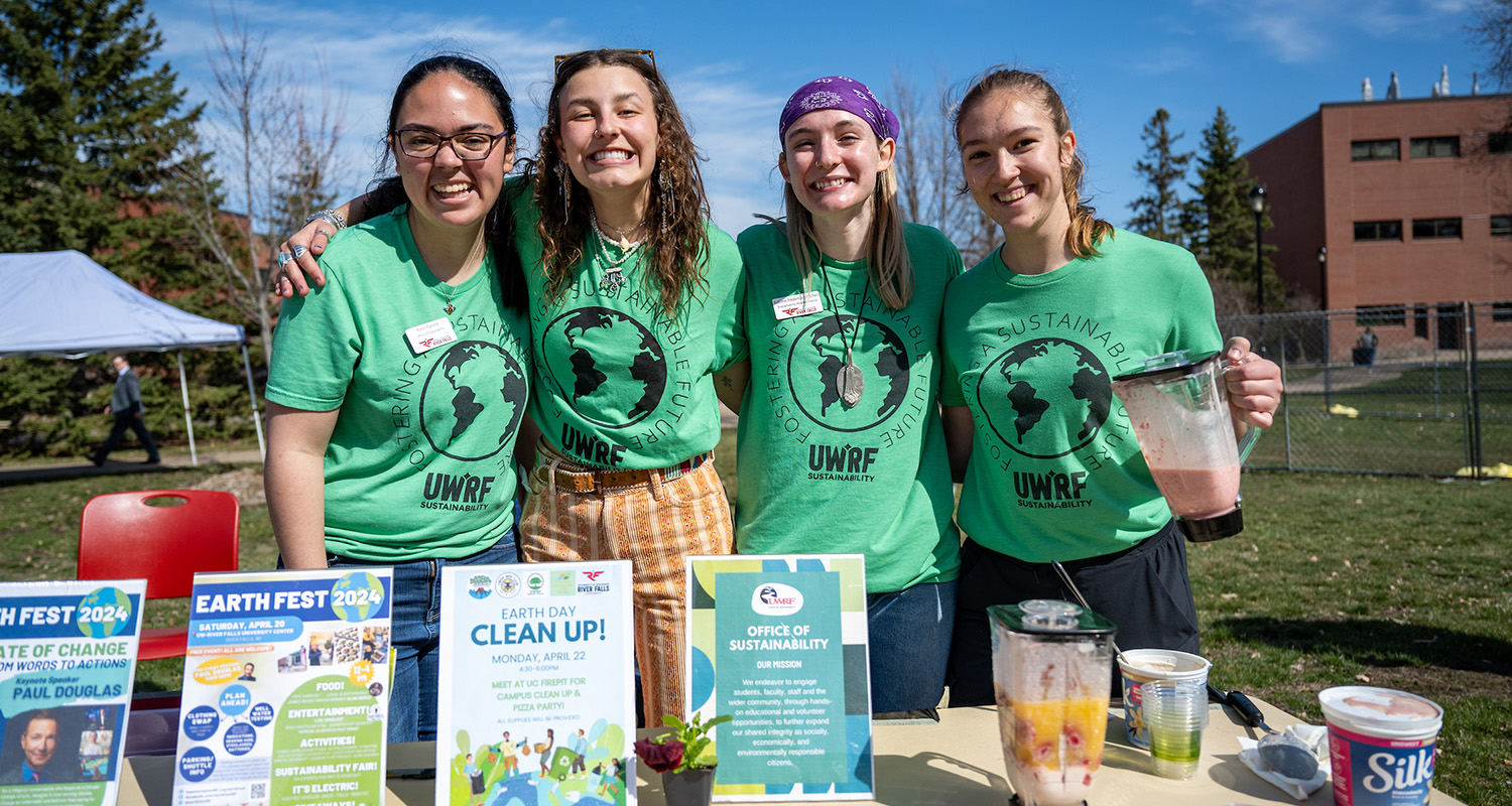 Four female students stand behind a table at the annual Agricultural Day on Campus event