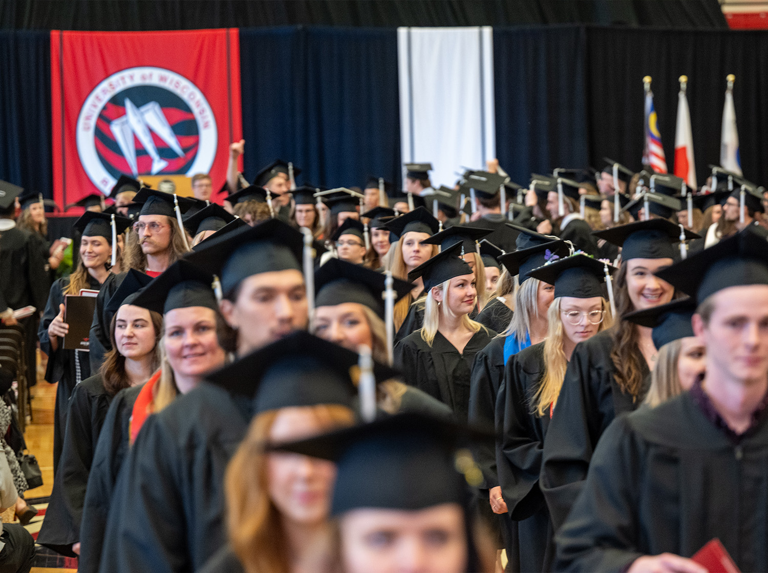 A crowd of graduates leaves the commencement ceremony