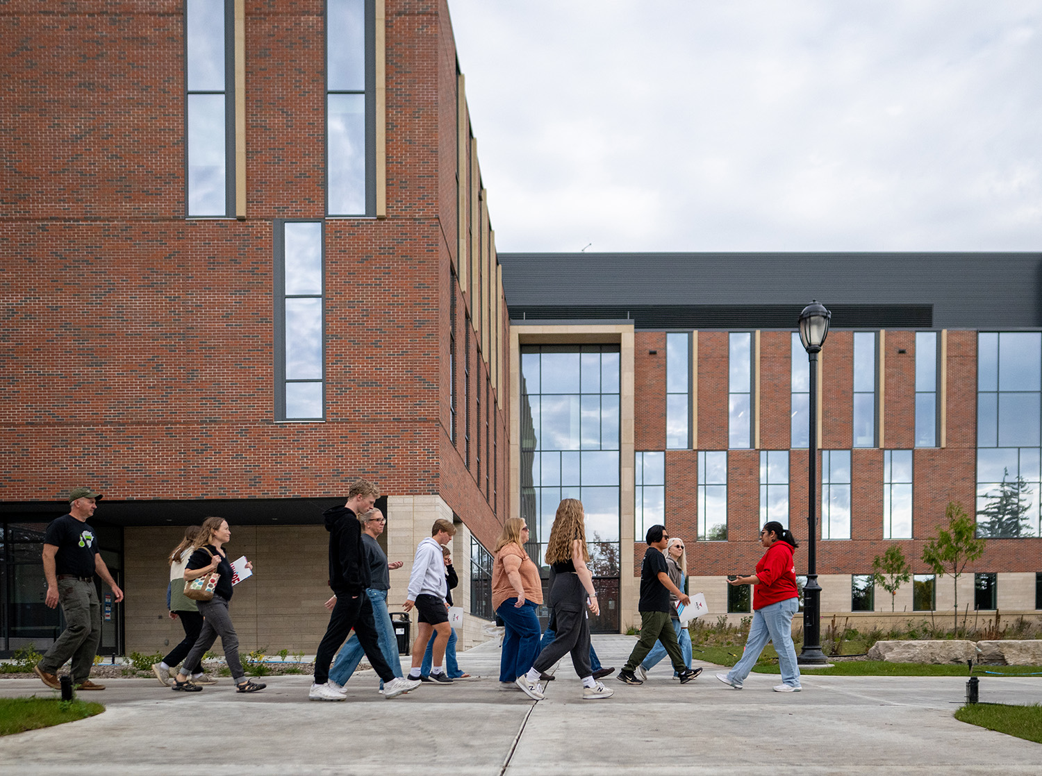 A student admissions tour guide leads a group past SciTech.