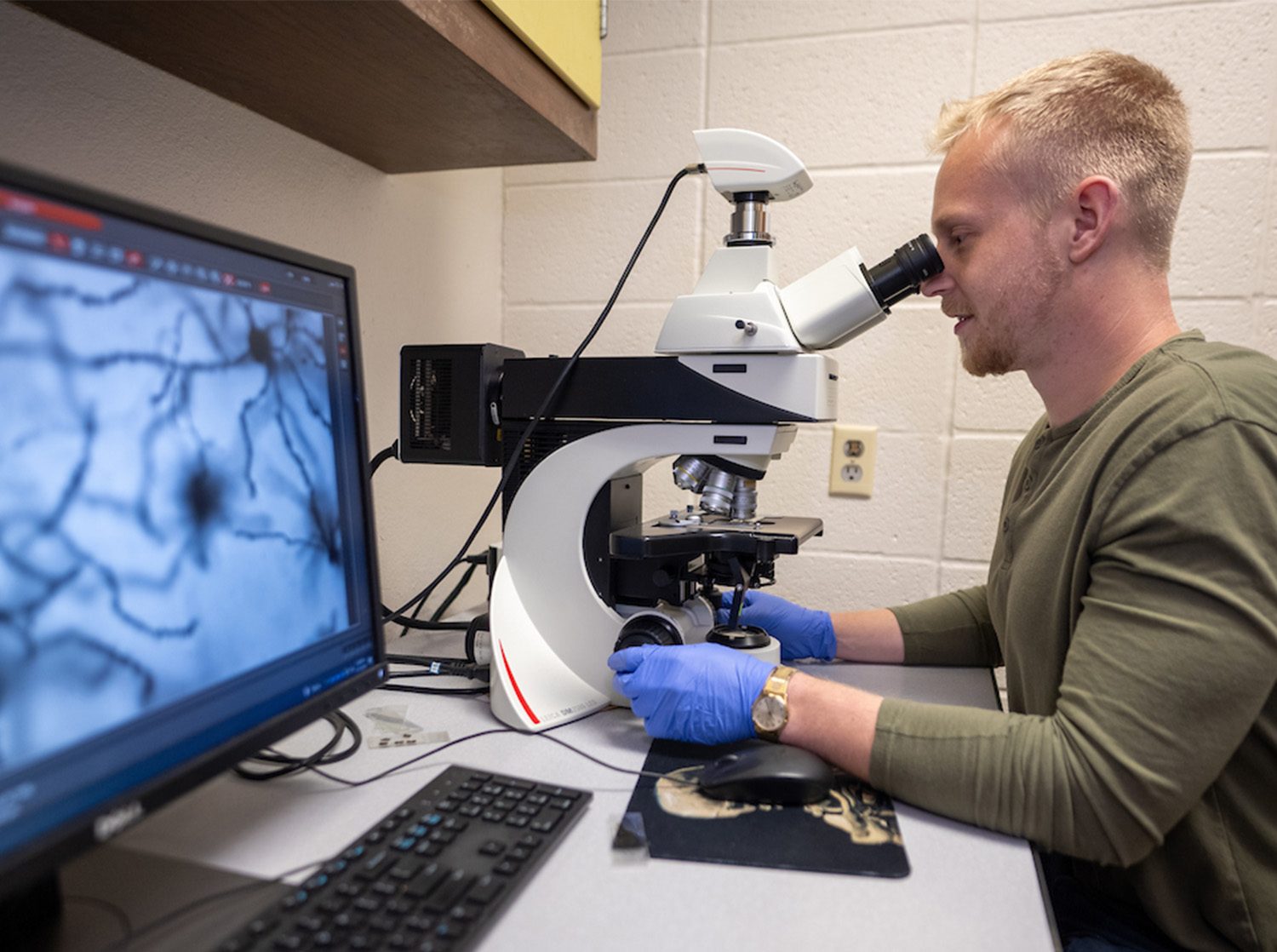 Psychological Sciences Student Looking Through Microscope