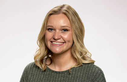 Headshot of Rebecca Redding, a young woman with short blonde hair and a dark green shirt