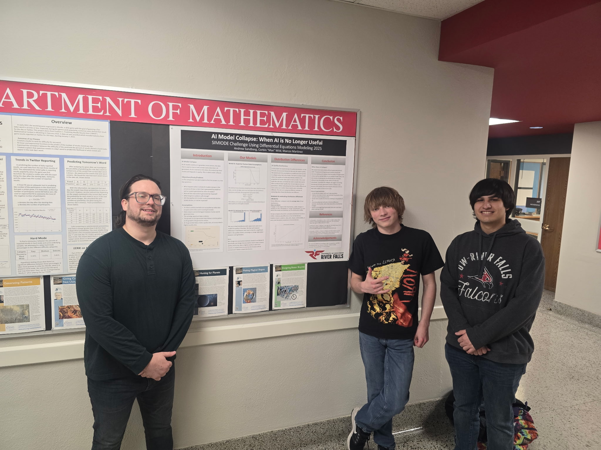 Three students, Andrew Sandberg, Max Wild, and Marcos Martinez, standing beside their poster at the 2025 SCUDEM competition.