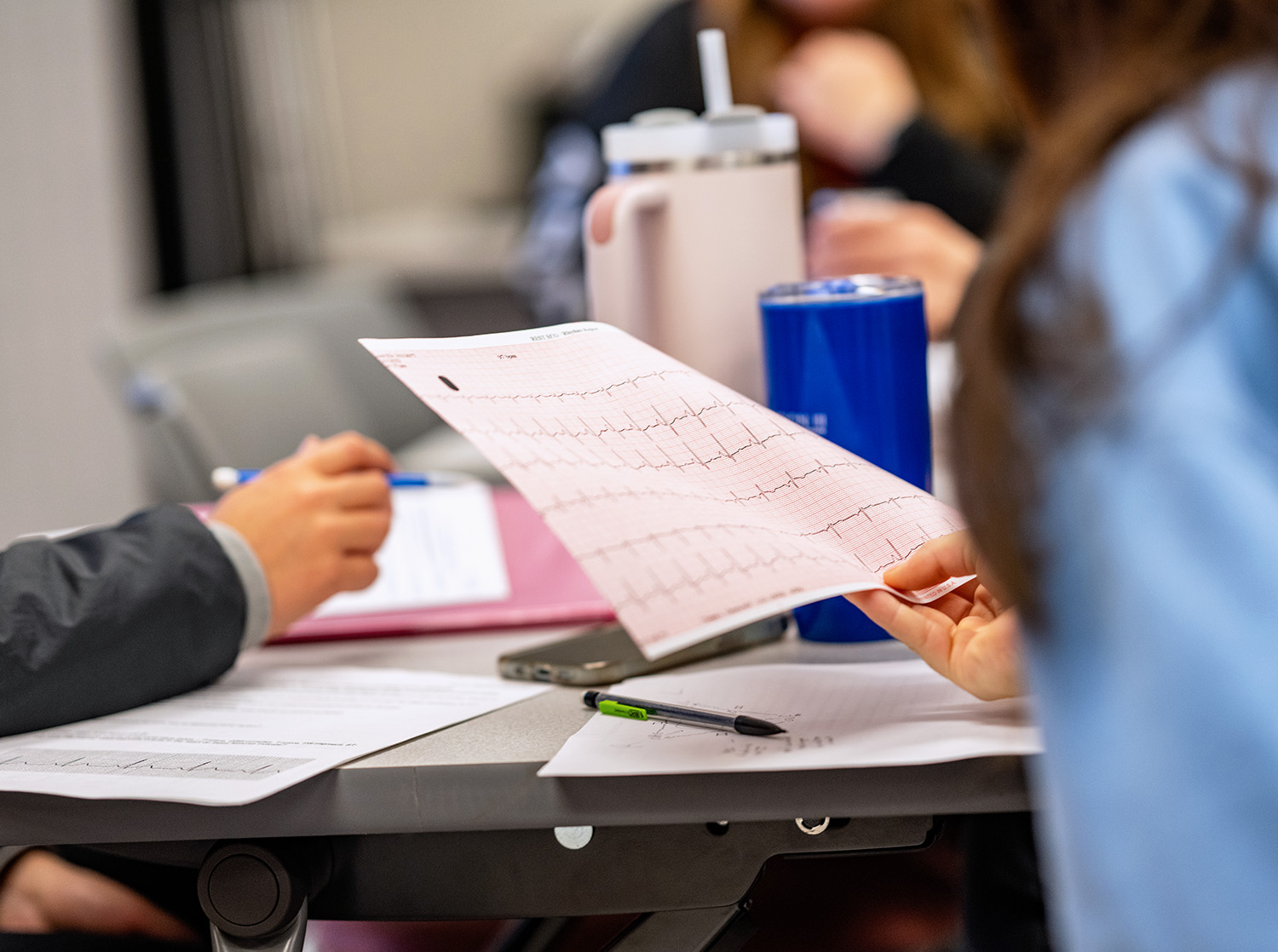 Students look at a heart monitor reading during class