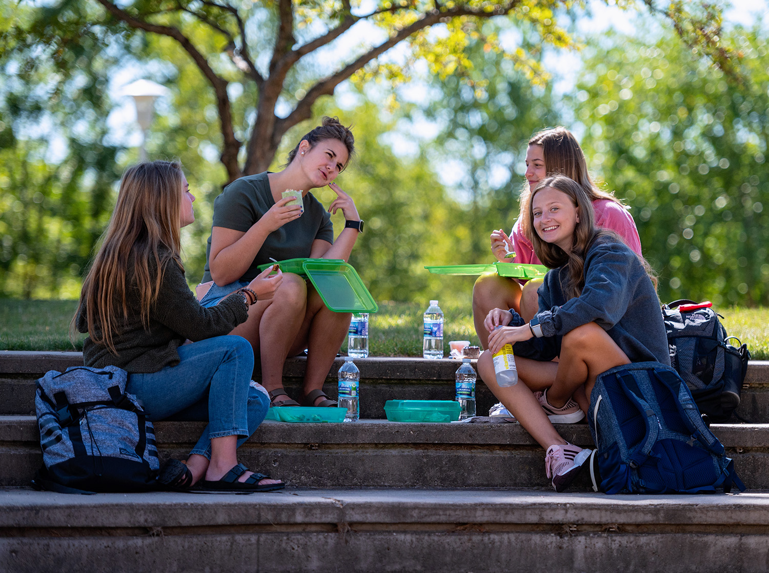 Four female students enjoy lunch outside on the UC lawn