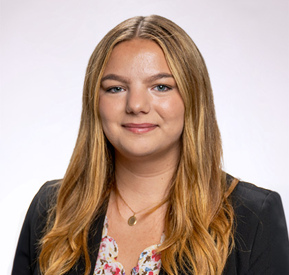 Headshot Sierra Bakke, a female student with long blonde hair wearing a gold necklace, patterned blouse and gray blazer