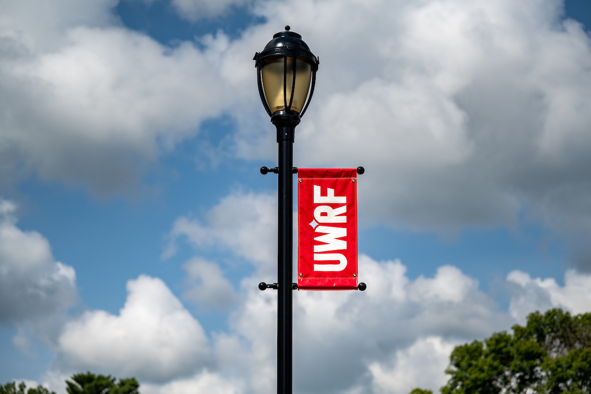 A red flag with the UWRF logo hangs from a lightpole