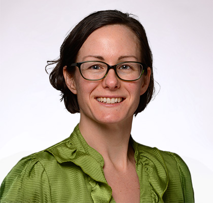 Headshot of Veronica Justen, a woman with short black hair and glasses wearing a lime green blouse