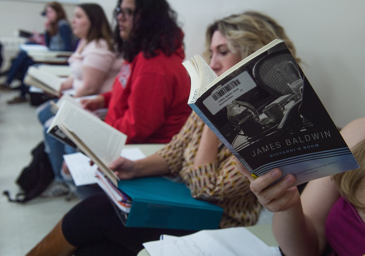 students hold a book and read during class