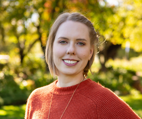Headshot of Samantha Edholm-Bean with a green trees background