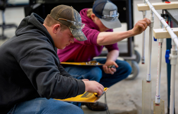 Two male students hold clipboards and collect data during an FFA event