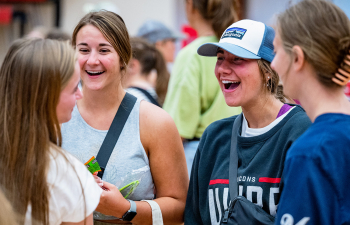 A group of women laugh together at the Involvement Fair in the Falcon Center