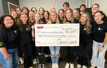 COMMS Students holding Large Check