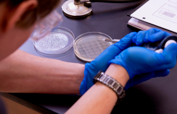 A student uses a pipette to gently place a liquid into a petri dish