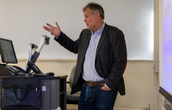 David Bonko speaks behind a podium to a marketing class