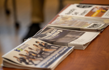 Multiple stacks of newspapers sit on a table