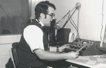 A black and white photo of a student in the WRFW radio studio