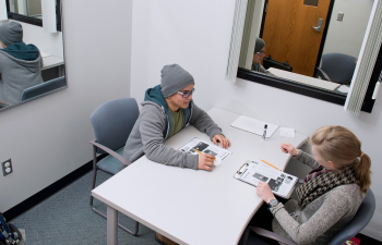 A male and female student sit across from each other at a table