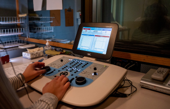 A student uses an audio device to test the hearing of another student