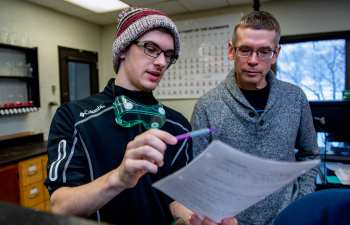 Professor Follensbee helps a student with their Chemistry lab exercise