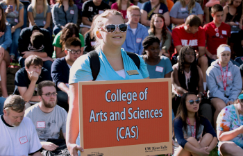 Student holds a sign that says College of Arts and Sciences during Academic Day