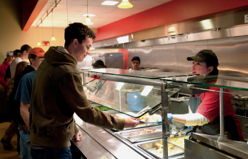 Student takes a plate from a dining