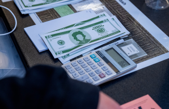 A table is set up for a mock simulation with prop money and a calculator