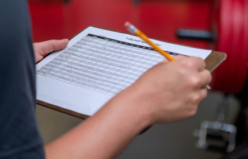 A student holds a clipboard with spaces to fill in data