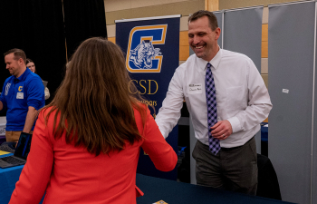 Student shakes the hand of an employer during the Education Career Fair