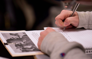 A student writes their notes in a notebook