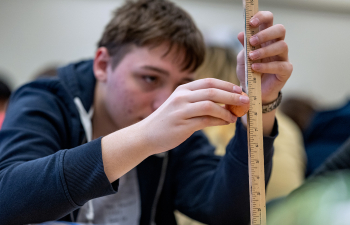 A person uses a measuring stick to take the height measurement