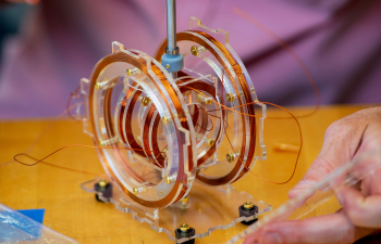 A physics professor conducts an experiment with plastic gears and copper wire