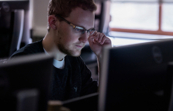 A student looks focused on their laptop screen