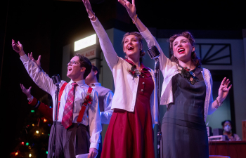 Three performers sing during the Christmas Carol play