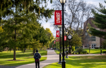 A student walks down a sidewalk on campus