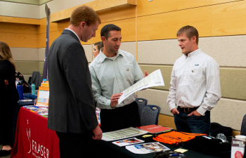 A male student speaks to an employer during the UWRF career fair.