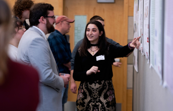 A female student points to information on a poster during the URSCA fall gala.