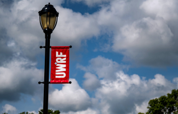 A light post on campus with the UWRF red banner