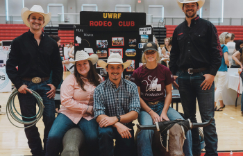 Five students pose in front of the UWRF Rodeo club booth at the Involvement fair