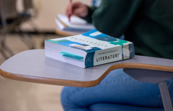 A literature textbook sits on a students desk