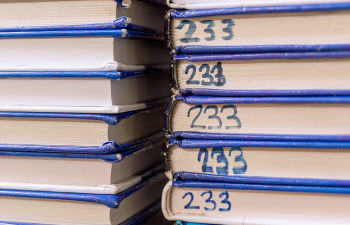 A stack of textbooks on a shelf