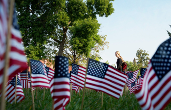 A large group of small flags stands in the ground outside of the University Center in honor of Veterans Day