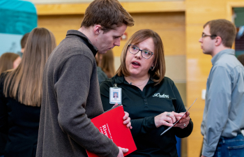 An employer speaks to a student during the career and internship fair