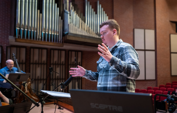 a male choir director leads a symphony orchestra