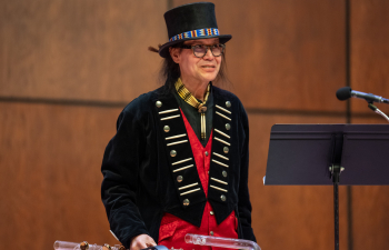 photo of Brent Michael Davids standing on stage holding his instrument.