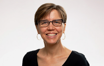 Headshot of Cyndi Kernahan, a middle aged woman with short cropped brown hair and a black blouse