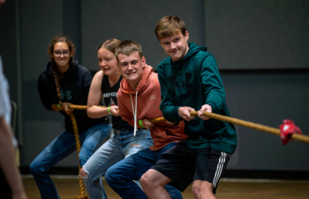 Four students participate in a tug-of-war during homecoming